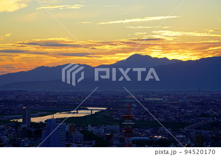 金華山ドライブウェイ展望台から見る伊吹山に沈む秋の夕日と夕焼け 94520170