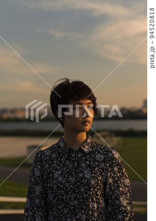 夕日 河川敷 ショートヘアの女性 94520818