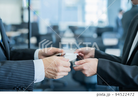 名刺交換をするミドル男性と若い女性　顔無し 94522472