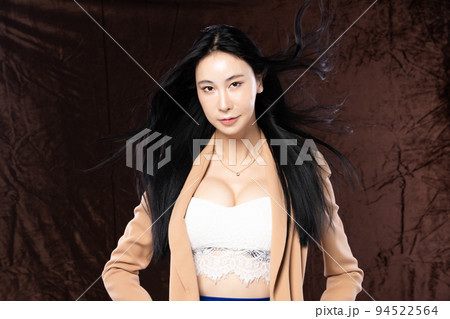 Haft body portrait of beautiful transgender 20s asian woman express feeling smiling confidently on brown background. Business Female smart look blazer has wind blow throw her hair in air, copy space Haft body portrait of beautiful transgender 20s asian woman express feeling smiling confidently on brown background. Business Female smart look blazer has wind blow throw her hair in air, copy space 94522564