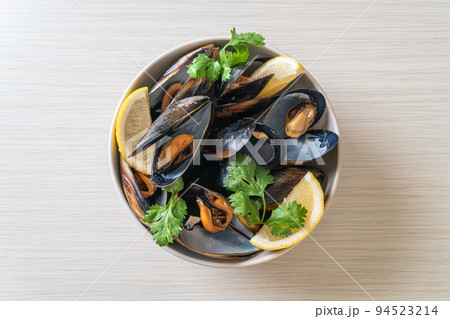 Mussels with herbs in a bowl with lemon 94523214