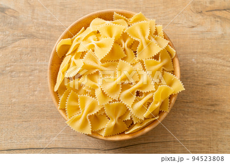 Dry uncooked farfalle pasta in bowl Dry uncooked farfalle pasta in bowl 94523808