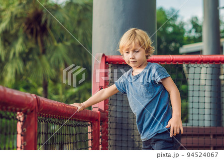 Adorable little toddler boy having fun on playground 94524067