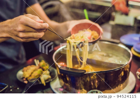 The man puts the soup in a plate The man puts the soup in a plate 94524115