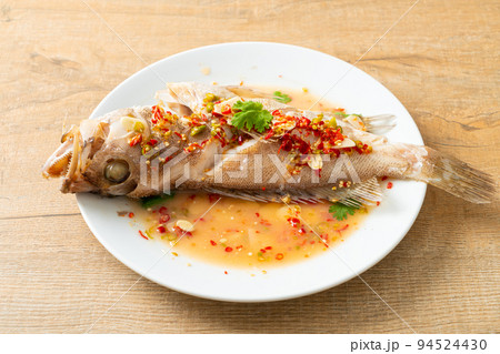 Steamed grouper fish with lime and chillies 94524430