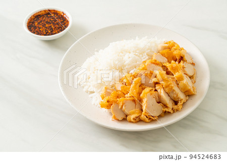 fried chicken topped rice with dipping sauce 94524683