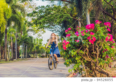 young beautiful woman riding a bicycle in a park. Active people. Outdoor young beautiful woman riding a bicycle in a park. Active people. Outdoor 94526055