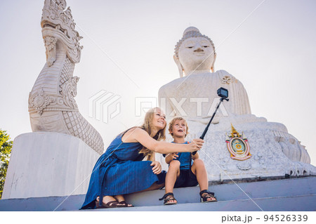Mother and son tourists on the Big Buddha statue. Was built on a high hilltop of Phuket Thailand Can be seen from a distance Mother and son tourists on the Big Buddha statue. Was built on a high hilltop of Phuket Thailand Can be seen from a distance 94526339