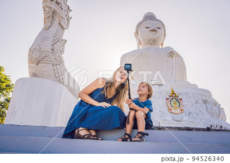 Mother and son tourists on the Big Buddha statue. Was built on a high hilltop of Phuket Thailand Can be seen from a distance Mother and son tourists on the Big Buddha statue. Was built on a high hilltop of Phuket Thailand Can be seen from a distance 94526340