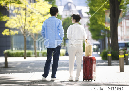 スーツケースを持つ旅行中の若いカップル 94526994