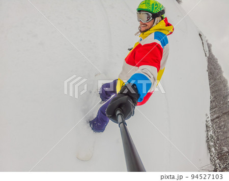 Skier skiing downhill during cloudy sunny day in high mountains Skier skiing downhill during cloudy sunny day in high mountains 94527103