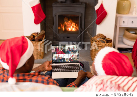 African american couple in santa hats on christmas video call with family 94529645