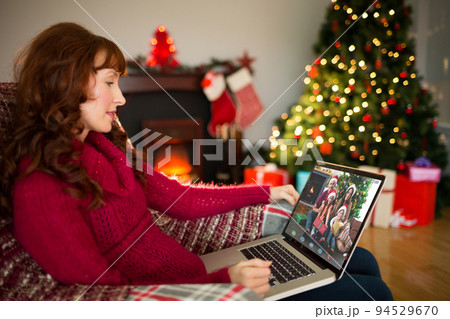 Caucasian woman on christmas laptop video call with diverse group of friends Caucasian woman on christmas laptop video call with diverse group of friends 94529670