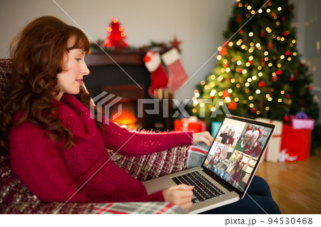 Caucasian woman on christmas laptop video call with diverse group of friends Caucasian woman on christmas laptop video call with diverse group of friends 94530468