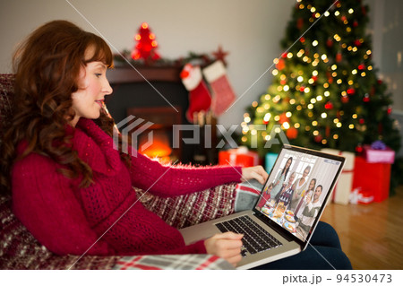 Caucasian woman on christmas laptop video call with diverse group of friends Caucasian woman on christmas laptop video call with diverse group of friends 94530473