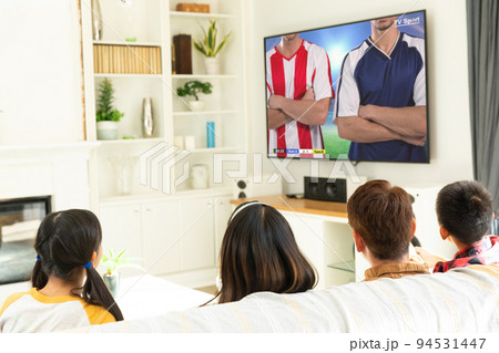 Diverse group of children siting on the couch and watching football match 94531447