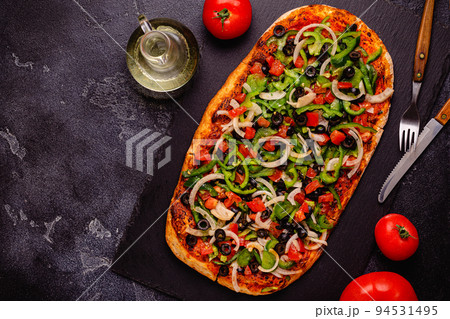 Homemade vegan pizza with tomatoes, peppers, olives, onions and herbs. 94531495