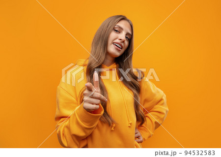 Young woman over yellow background points finger at you Young woman over yellow background points finger at you 94532583