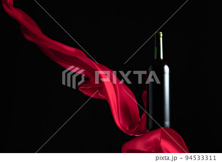 Bottle of red wine on a black background. 94533311