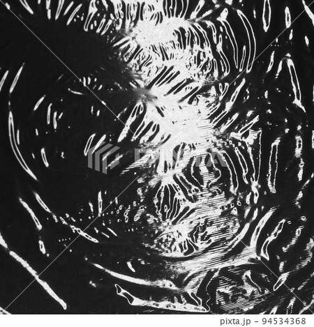 Reflected light and shadow on creases and folds in black plastic sheeting 94534368