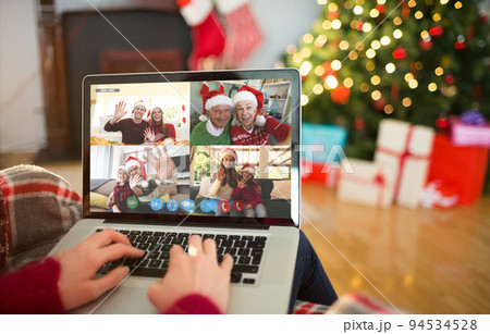 Caucasian woman making christmas laptop video call with waving friends and family 94534528