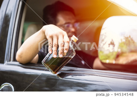 man drunk during drive a car. driver with alcohol whisky bottle dangerous and illegal concept. man drunk during drive a car. driver with alcohol whisky bottle dangerous and illegal concept. 94534548