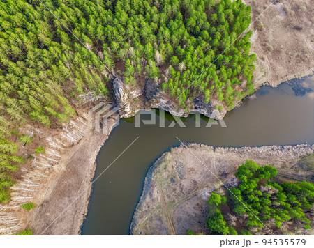 Aerial view of river shore with rocks and forest. Spring or autumn season. Iset River, Ural mountains, Russia. Aerial view of river shore with rocks and forest. Spring or autumn season. Iset River, Ural mountains, Russia. 94535579