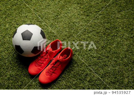 Composition of football and shoes over sports stadium and copy space 94535927