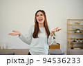 Joyful and happy Asian woman having a great time, smiling and dancing in her living room. 94536233