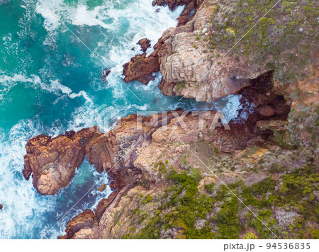 High angle view of sea waves and sea shore with rocky cliff shore High angle view of sea waves and sea shore with rocky cliff shore 94536835