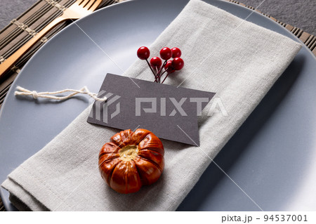 Close up of thanksgiving place setting with tag and autumn decoration on slate Close up of thanksgiving place setting with tag and autumn decoration on slate 94537001