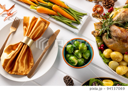 Overhead view of thanksgiving table with roast turkey, vegetables and autumn decoration on wood 94537069