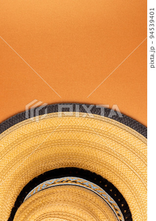 Vertical image of straw hat on yellow surface 94539401
