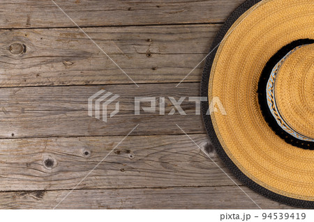 Image of straw hat lying on wooden surface 94539419