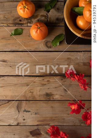 Composition of red flowers and oranges on wooden background Composition of red flowers and oranges on wooden background 94539791