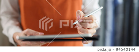 Tablet with stylus in female hands in uniform closeup 94540144