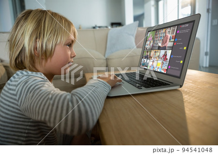 Caucasian boy using laptop for video call, with smiling diverse elementary school pupils on screen Caucasian boy using laptop for video call, with smiling diverse elementary school pupils on screen 94541048