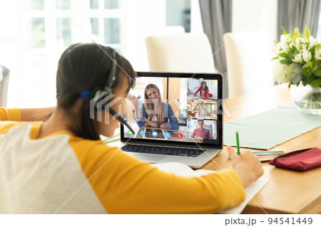 Asian girl using laptop for video call, with diverse high school pupils on screen Asian girl using laptop for video call, with diverse high school pupils on screen 94541449