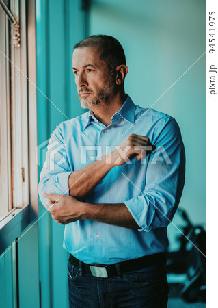 Portrait of modern senior businessman in suit with crossed arms 94541975