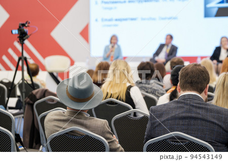 Group of people watching presentation on large screen 94543149