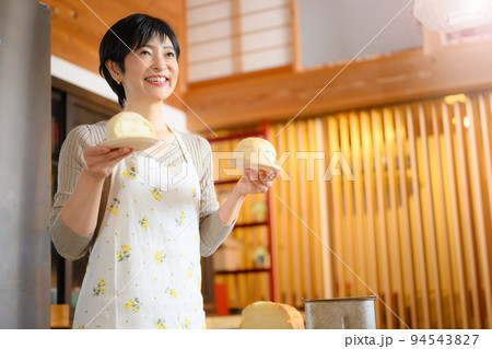 出来立てのパンを持つ素敵なお母さん 94543827
