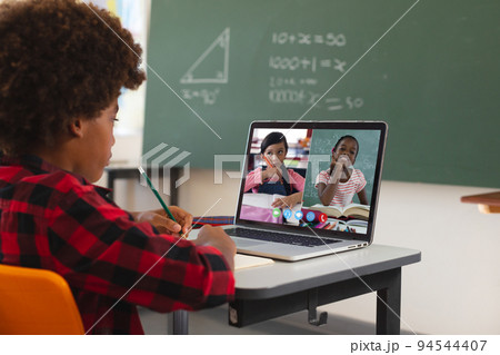 African american boy using laptop for video call, with diverse elementary school pupils on screen African american boy using laptop for video call, with diverse elementary school pupils on screen 94544407