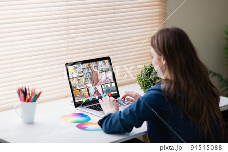 Caucasian girl using laptop for video call, with smiling diverse high school pupils on screen 94545088