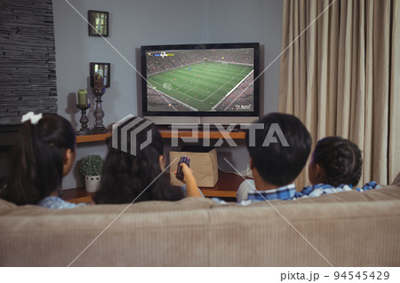 Diverse children watching tv with football match on screen 94545429