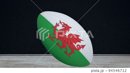 Composition of rugby ball decorated with the flag of wales on black background 94546712
