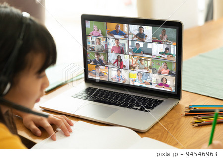 Asian girl using laptop for video call, with smiling diverse elementary school pupils on screen Asian girl using laptop for video call, with smiling diverse elementary school pupils on screen 94546963