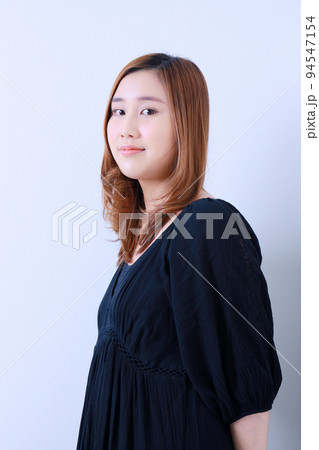 黒色のワンピース姿の若い女性 94547154