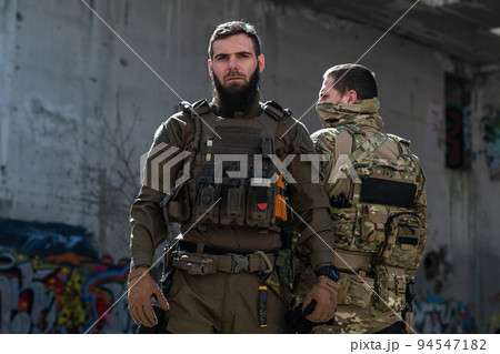 Modern warfare soldiers in dark with combat ammunition and weapons in the hands of equipped laser sights are in battle order. Mixed media.  94547182