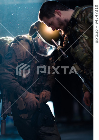 Modern warfare soldiers in dark with combat ammunition and weapons in the hands of equipped laser sights are in battle order. Mixed media.  94547310