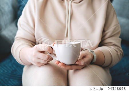 Self care, staying home, cozy mood. Take care of yourself, Love yourself concept. Woman hands with cup of hot drink at home 94548048